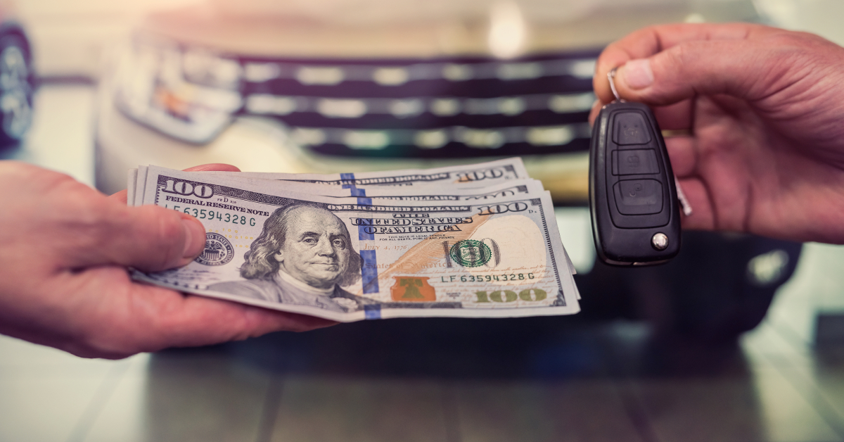 Hand with dollar money and car keys