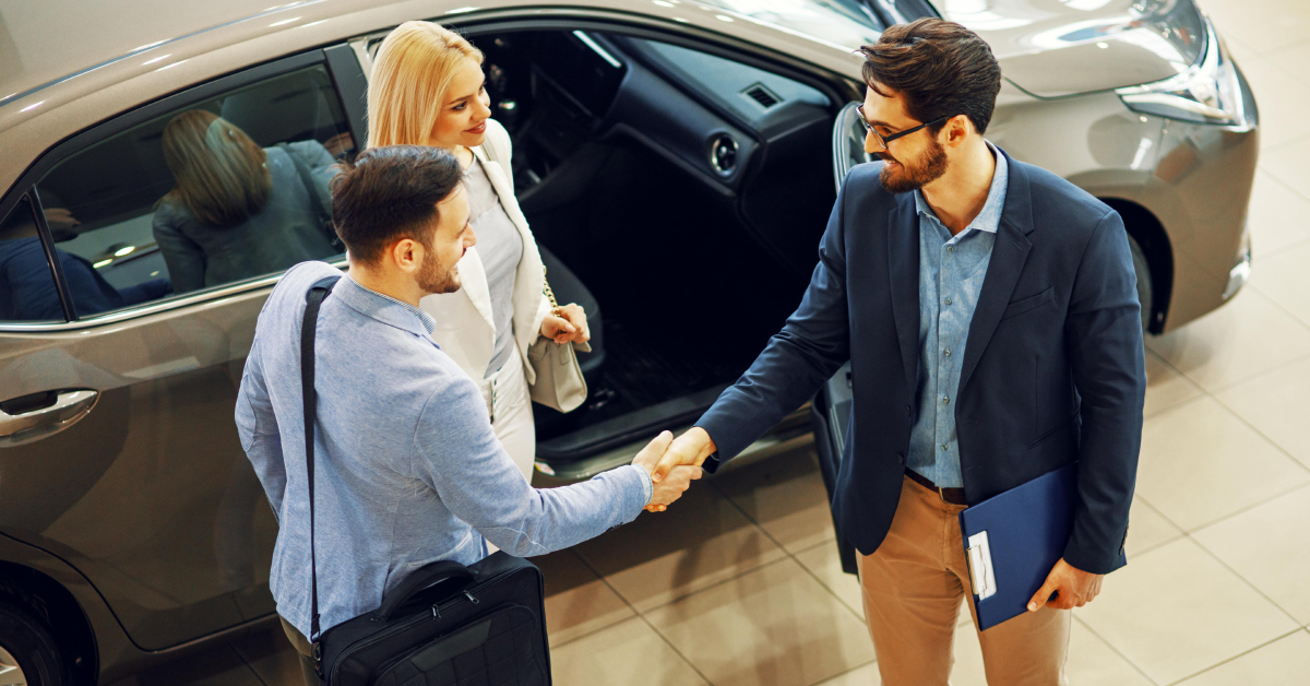 a couple making a deal with a car salesman