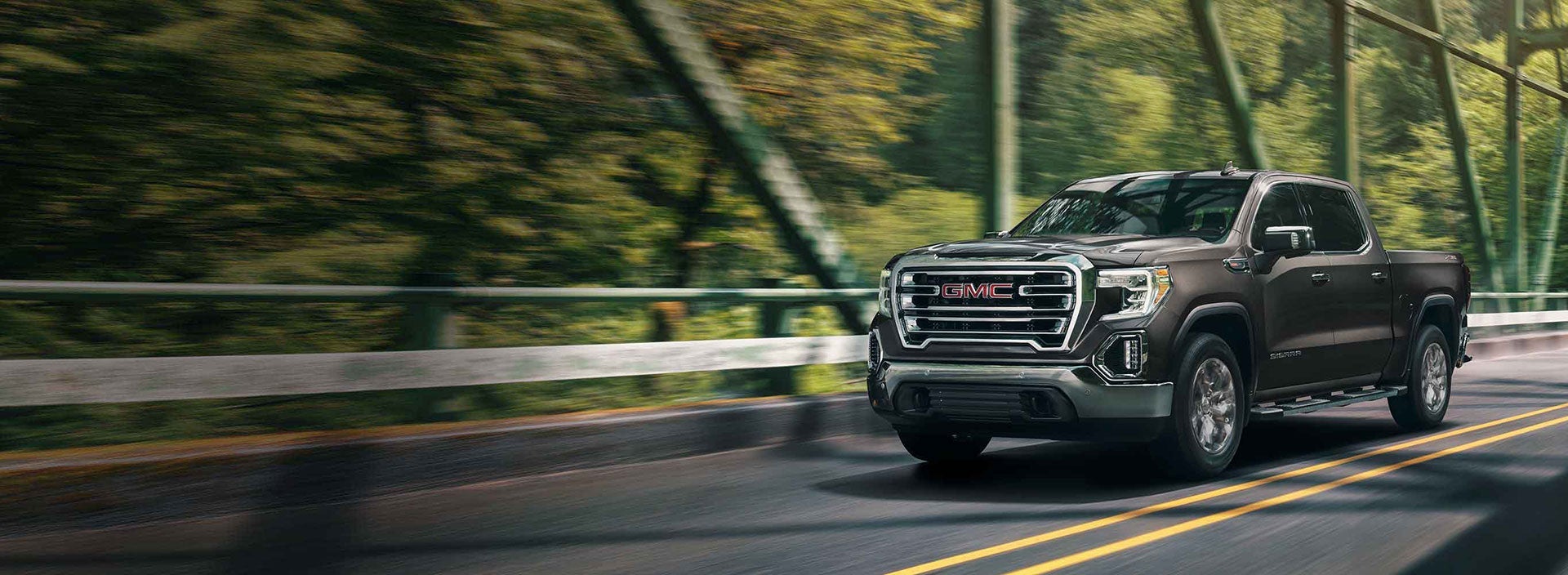 GMC truck driving down a country road